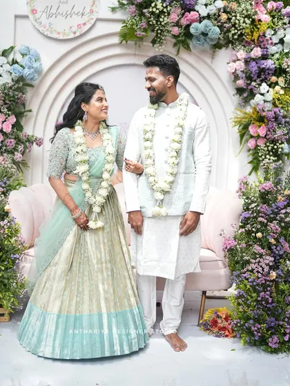 A wide shot of the couple against their beautiful floral backdrop.