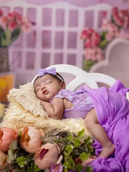 A lavender dream. This elaborate setup uses a miniature chaise lounge and a backdrop of purple and pink flowers to create a truly royal portrait.
