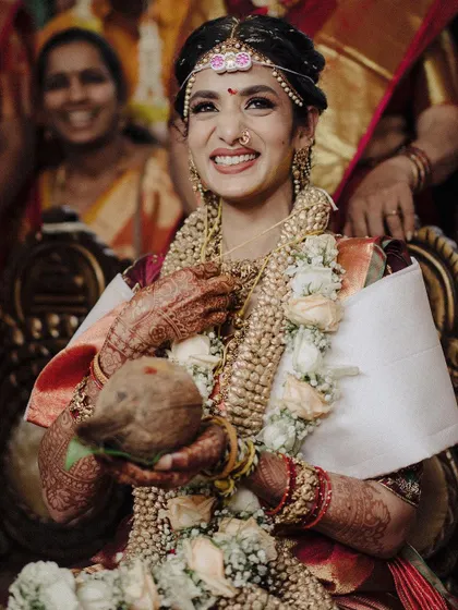 Holding the sacred coconut, this South Indian bride beams with happiness. I focused on capturing her joyful expression and the intricate details of her mehndi and jewelry during the ceremony.