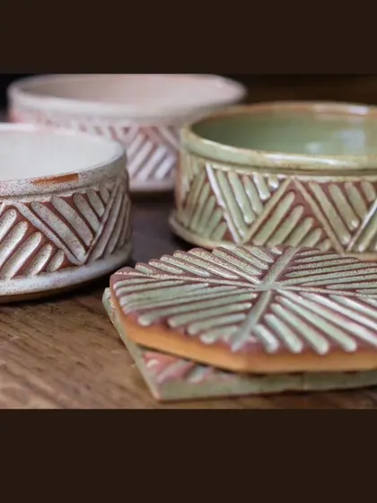 These lidded jars and coasters are part of the KHUMĀR collection. The carving is consistent across all pieces, making it a cohesive set for hosting.