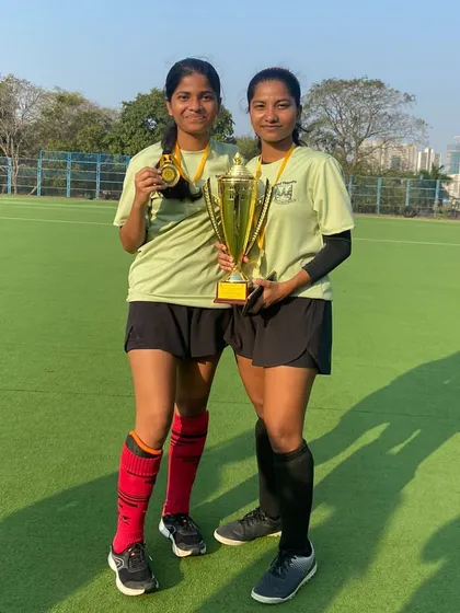 Our talented players, Kabira and Arhata, proudly display their trophy and medals after winning the Intercollegiate Mumbai University Hockey Tournament. Their success has qualified them for the All India University Championship.