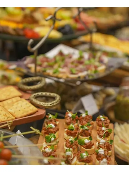 A detailed shot of our grazing table, showing layers of different appetizers like bruschetta and crackers, creating a visually dense and appetizing display.