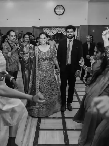 A black and white shot of a joyful entry, with friends dancing and creating a path for the couple. This timeless image captures the pure happiness and energy of the celebration.