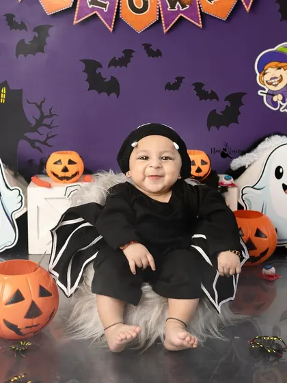 A happy little bat. This baby's smile shows that Halloween themes can be more cute than spooky.