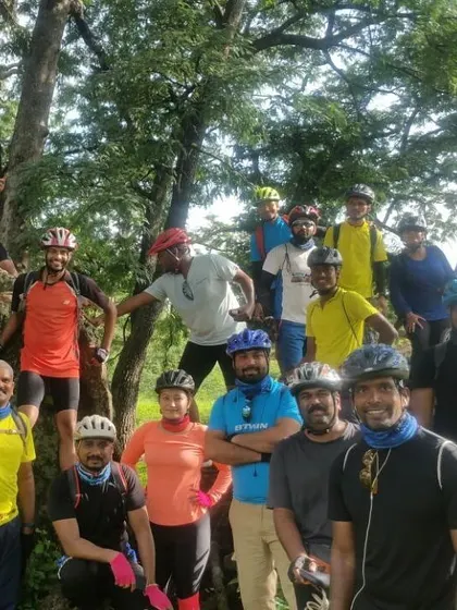 A fun, candid group photo with riders perched on tree branches during a break.