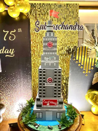 The full view of the massive building cake, set up at the 75th birthday party.
