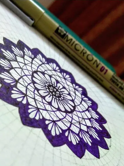 A work-in-progress shot of the violet mandala. This shows the beginning stages, where the central patterns are laid down before the outer layers are added.
