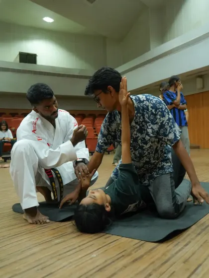 A different angle of our ground defense drill. The instructor guides a student on how to maintain a defensive posture and protect themselves while another student simulates an attack.