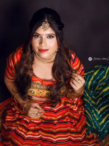 This top-down angle showcases the complete festive look, from the maang tikka to the soft waves in the hair. The makeup is designed to be bold and camera-ready, perfect for a celebratory photoshoot.
