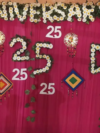 A custom backdrop I created for a 25th anniversary party. I used white flowers to spell out 'ANNIVERSARY' and create the number '25' against a bright pink curtain.