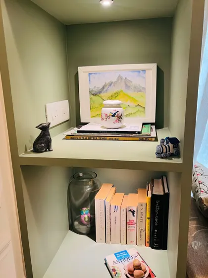 Even small nooks can become stylish features. We designed this built-in bookshelf with a smooth, sage green PU finish and integrated downlighting to create a perfect spot for displaying art and personal treasures.