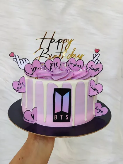 A cake for the BTS army. This purple drip cake is decorated with the BTS logo and hearts featuring the names of all the band members.