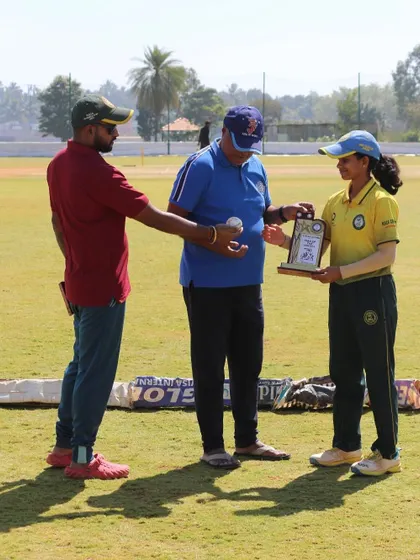 A young female player is presented with a trophy and a match ball for her outstanding performance.