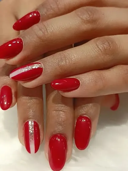 A simple and chic red manicure with a single accent nail featuring a clean silver stripe.