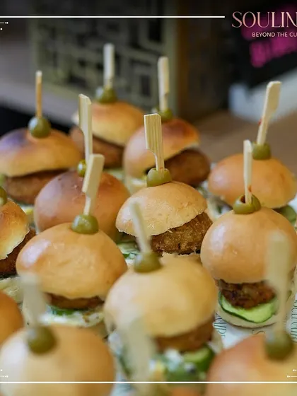 A close-up of delicious mini-burgers, or sliders, prepared for a corporate expo. Our menus include a variety of crowd-pleasing options suitable for any event format.
