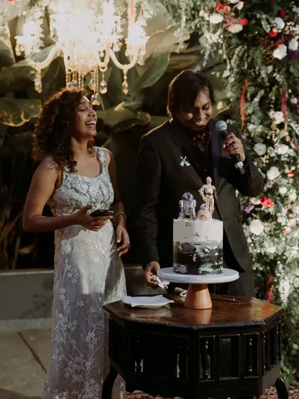 The couple shares a laugh while cutting their unique Star Wars themed wedding cake, a perfect example of how we personalize every detail.