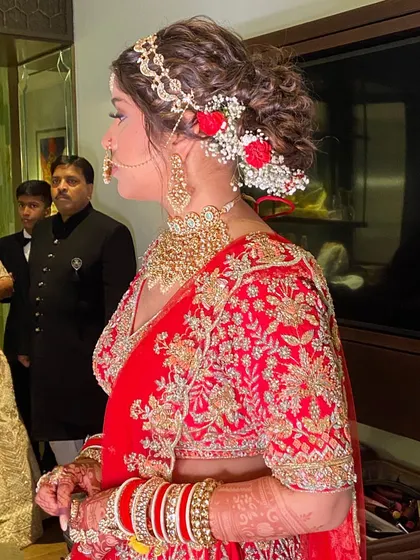 A side view of the messy bun, adorned with small red and white flowers.