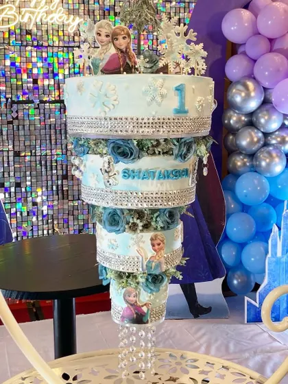 A Frozen-themed chandelier cake for a magical first birthday. This design combines the elegance of a hanging cake with the fun of a beloved Disney movie, complete with shimmering details and characters.