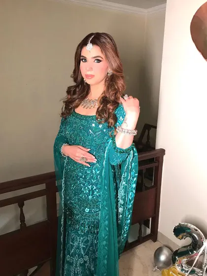 A full shot of the client in a beautiful green outfit, her hair styled in elegant curls. The hairstyle adds a touch of sophistication to her festive look.