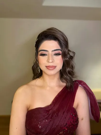 Creating timeless beauty for Jasleen's reception. I designed a look with dramatic winged eyeliner and a soft mauve lip to complement her stunning one-shoulder maroon gown.