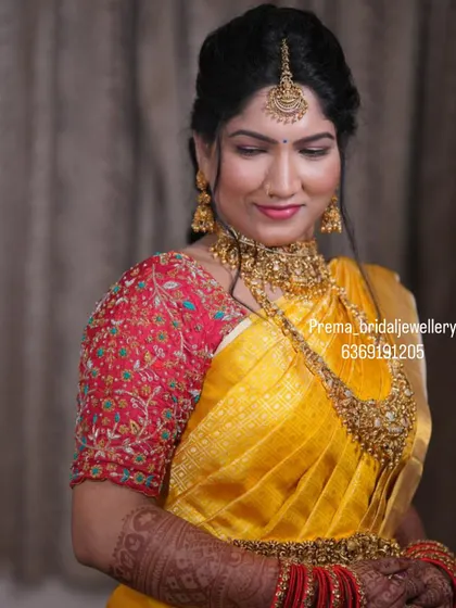 A beautiful shot of the bride in her yellow saree, highlighting the intricate details of the antique necklace set.