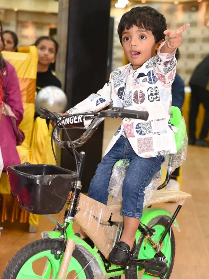 A fun, action shot of the birthday boy receiving a new bicycle as a gift.