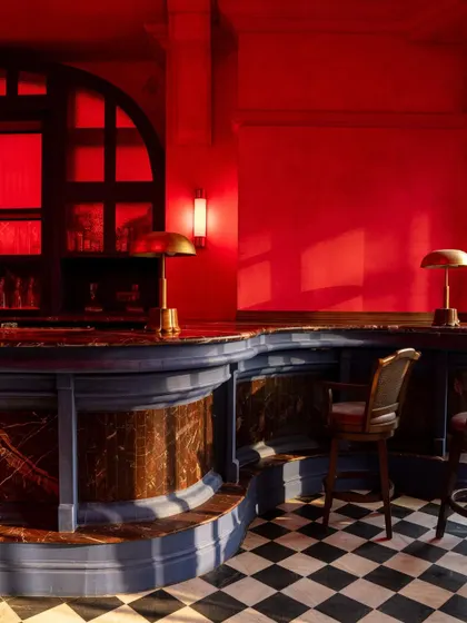 A detail of the curved bar counter at BANNG, featuring blue paneling and a marble top. This corner demonstrates the rich material and color palette, where deep blues and reds create a dynamic, culturally infused dialogue.