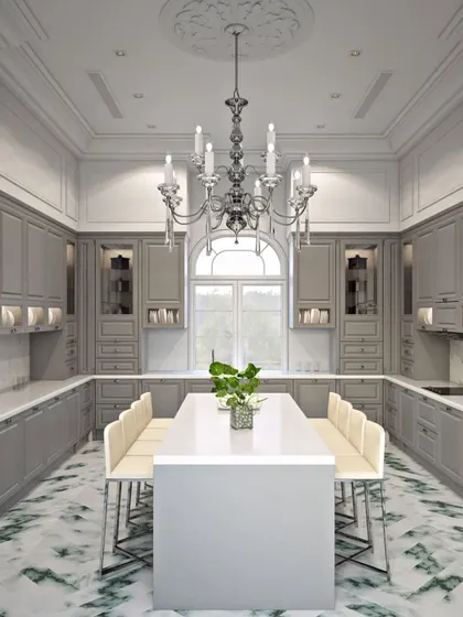 The expansive kitchen with a large central island for dining and prep, featuring a classic candelabra chandelier and striking green and white marble flooring.