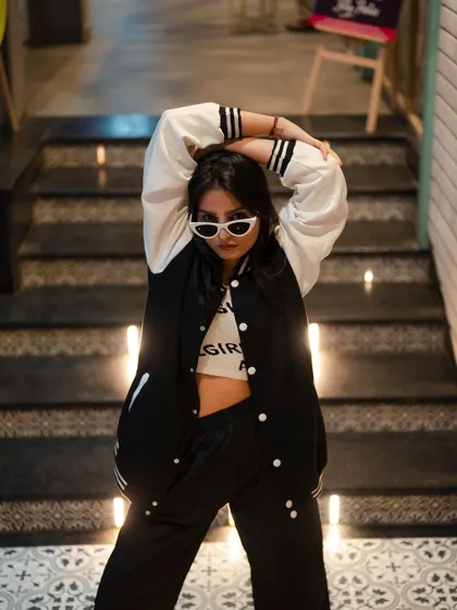 A dynamic pose on a staircase. The model's pose and the unique angle create a high-energy fashion shot that is full of attitude.