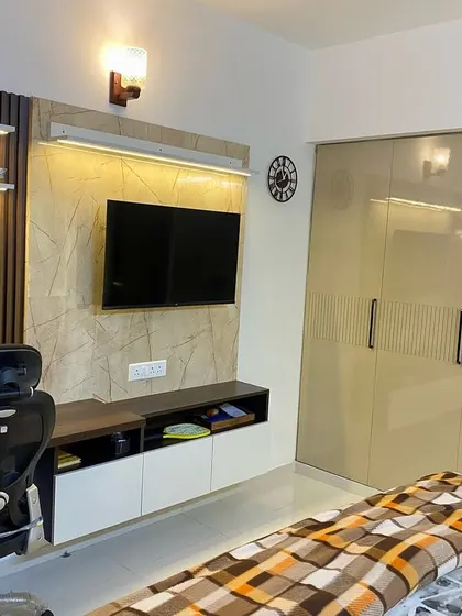 A multi-functional bedroom wall that includes a TV unit, a study desk, and a full-height wardrobe. This is a great solution for compact spaces.