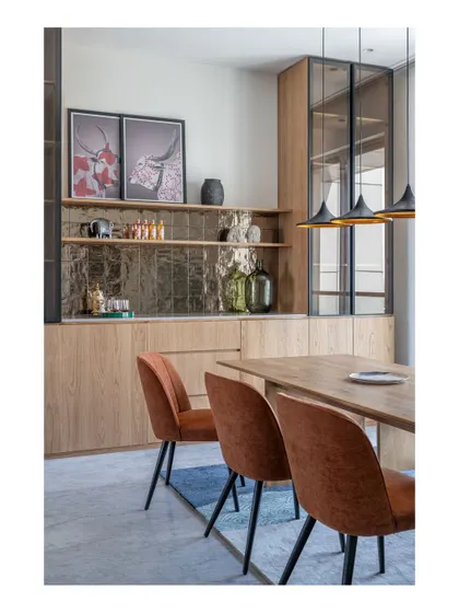 The bar and dining area in the Bombay Blue home. The custom bar unit features antique-finish mirror tiles and provides ample storage, making it a stylish and functional hub for entertaining.