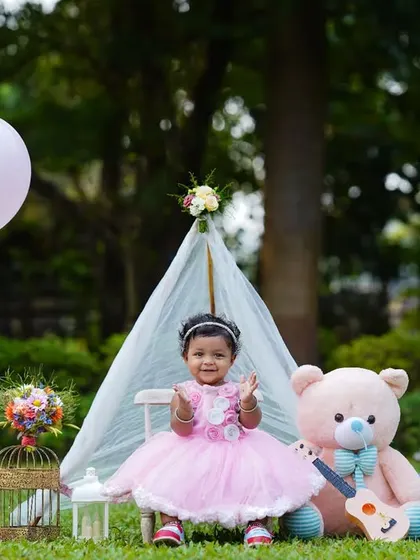 A complete first birthday setup outdoors, featuring a teepee, teddy bear, and festive props. This image showcases a full-concept outdoor birthday celebration shoot.