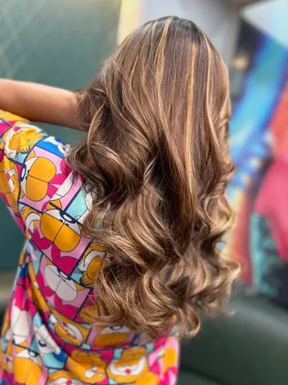 The back of this golden-highlighted hair, showing the full effect of the color and waves.