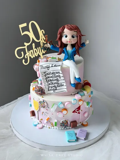A 50th birthday celebration in style. This fun, two-tiered cake is decorated with candy and features a list of the birthday girl's favorite things.