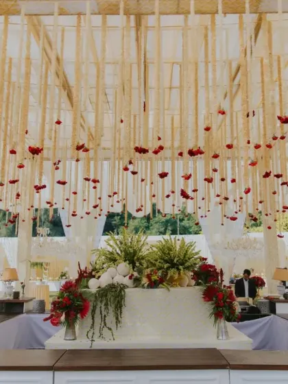 A ceiling of delicate floral hangings, known as 'kaleeras', interspersed with red roses. This design element added a traditional yet elegant touch to the Anand Karaj ceremony, creating a beautiful canopy above the guests.