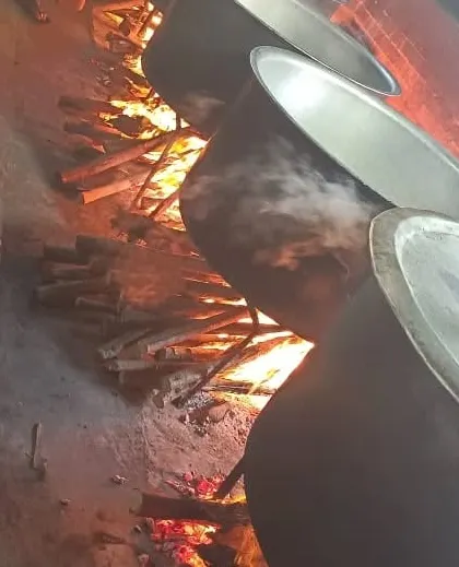 The sight of our large cooking vessels over a roaring wood fire. This traditional method is key to the authentic flavour of our food.
