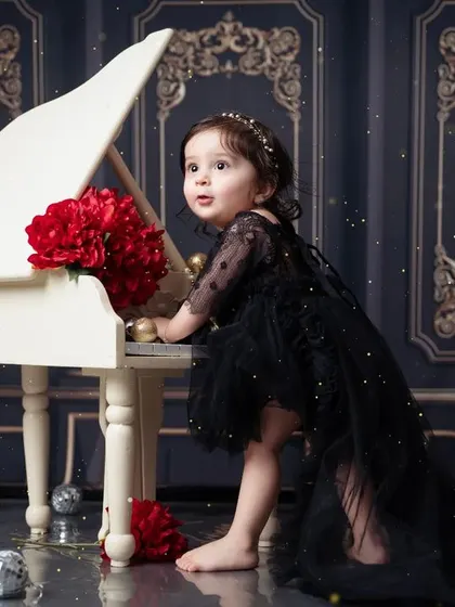 A curious glance from the birthday girl at our elegant piano setup. A timeless first birthday portrait.