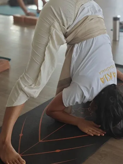 This image captures the dedication of a TTC student in a deep forward bend, a testament to the progress made through consistent practice and the supportive environment of our shala.