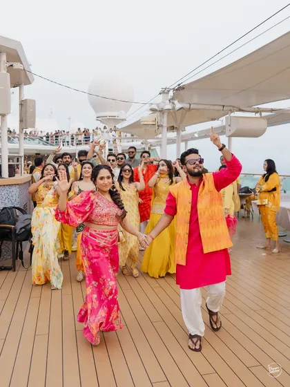 The bride and groom leading their crew in a dance on the deck of the Cordelia Cruise. A Haldi celebration on the Arabian Sea is a vibe of its own.