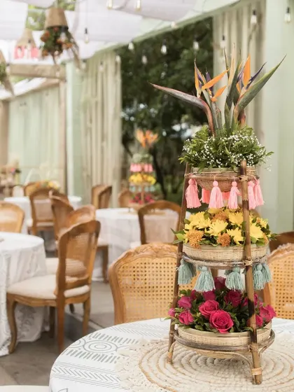 Our table centerpieces for the boho-themed Mehendi feature tiered bamboo stands decorated with colourful flowers and playful tassels. These details add a touch of whimsical charm and texture to the guest tables.