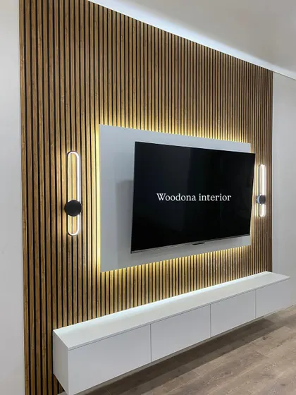 Another angle of this popular fluted panel TV unit design. The vertical lines of the wood paneling draw the eye upward, making the wall feel taller, while the backlighting adds a soft, ambient glow.
