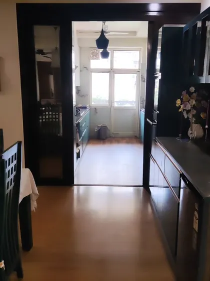 This view from the dining area shows how the kitchen connects to the living space. The dark wood frame creates a beautiful transition between the two zones.