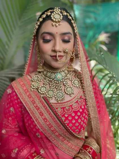 A serene shot of the bride, giving a closer look at the intricate details of the mint green meenakari necklace and the matching nath.