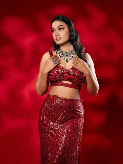 A closer view of the emerald necklace against the red gown, highlighting the beautiful colour contrast.