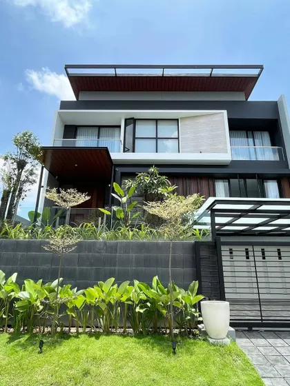 This modern home features a tiered landscape design. We used a retaining wall to create different levels, planting lush greenery at the base and more delicate trees on the upper tier to soften the contemporary architecture.