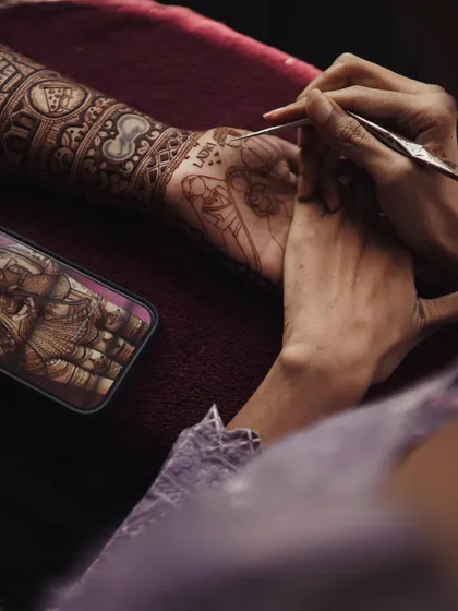 The process of creating a story. Here I am, using a photo reference to draw a portrait of the bride's family directly onto her arm.