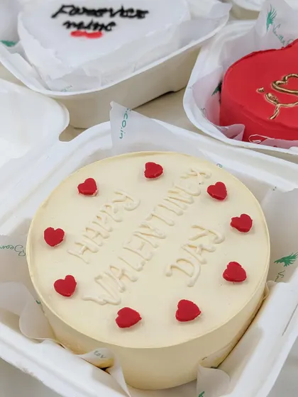 A simple and sweet "Happy Valentine's Day" bento cake. The clean design with tiny red hearts makes it a charming and classic choice for the occasion.