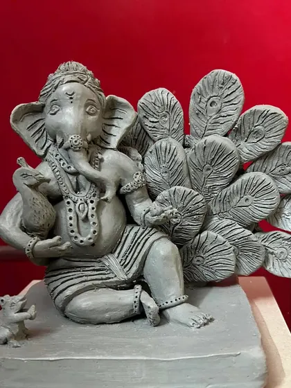 Beyond painting, I also sculpt. This is a 'Majha Bappa' idol I created by hand using shadu clay, complete with intricate details like the peacock and mouse.