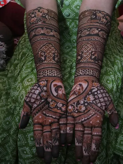 A beautiful example of combining couple portraits with floral and geometric patterns. The heart-shaped frame around the figures adds a romantic touch to this intricate bridal design.