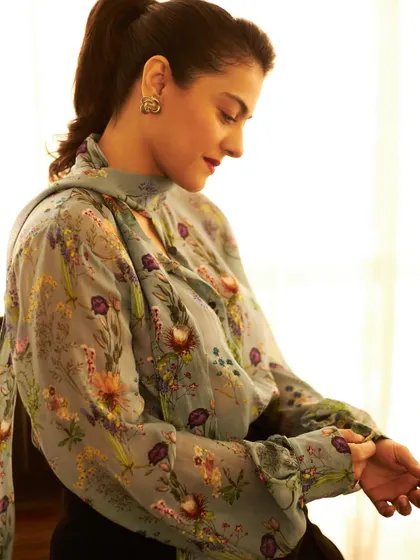 Kajol in a vintage-inspired floral blouse with a pussy-bow tie, a look that is both romantic and sophisticated.